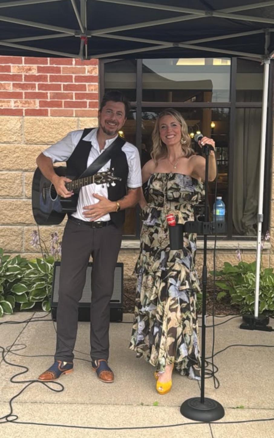 Mia and Alex smiling at an outdoor performance